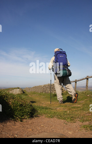 Wanderer zu Fuß entlang der Hadrianswall entlang der höchste Punkt an Windschutzscheibe Felsen. Stockfoto