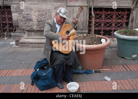 50-60 jährige blinde männliche Musiker spielt seine Gitarre und spielt es mit einem Kürbis auf der Straße in Quito, Ecuador. Stockfoto