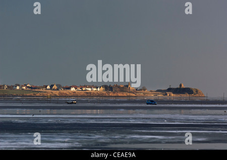 Insel Lindisfarne (heilig) und Dorf, mit zwei Autos ging den Gezeiten Causeway über das Wattenmeer. Stockfoto