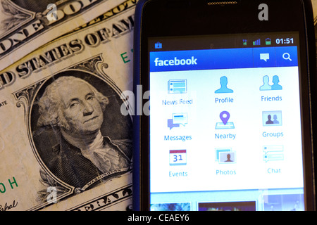 Facebook auf einem Smartphone Handy auf Dollarnoten liegend Stockfoto