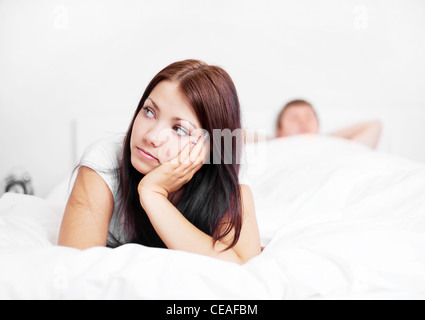junge Frau und Mann, die Probleme in den Beziehungen auf dem Bett zu Hause (Fokus auf die Frau) Stockfoto
