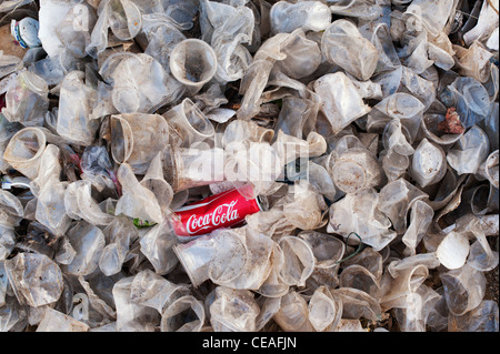 Ausrangierte Coca Cola können Getränke und Kunststoff Teetassen in der indischen Landschaft Stockfoto