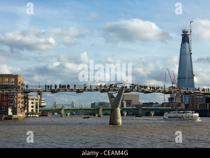 Menschen auf der Millennium Bridge, London England, Tower Bridge und The Shard (kurz vor der Fertigstellung), im Hintergrund. Stockfoto