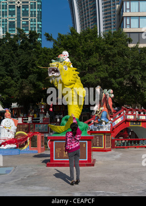 dh REPULSE BAY HONG KONG chinesisches Mädchen werfen Geld in Fisch Wohlstand Statue Mund Stockfoto