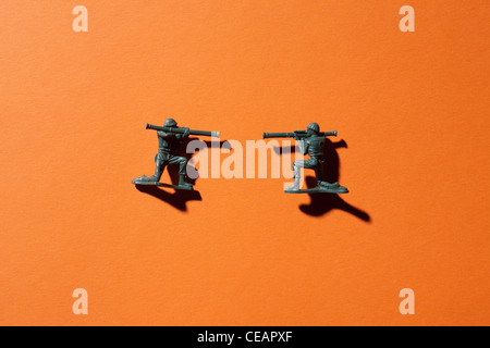 Zwei Spielzeugsoldaten auf orangem Hintergrund Stockfoto