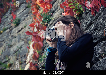 Ein junges Mädchen mit einem alten Vintage-Kamera fotografieren Stockfoto