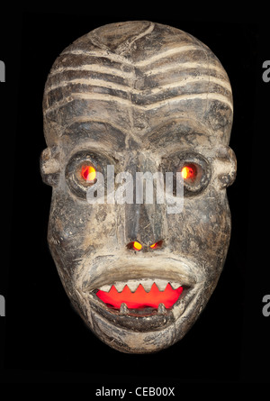 Geschnitzte afrikanische Stammes-Holzmaske, dunklem Holz mit bemaltem Gesicht. Auf schwarzem Hintergrund isoliert. Kongo, Afrika Stockfoto