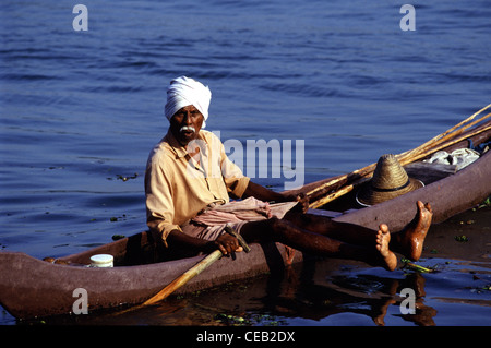 Ein Fischer tragen Safa Kopfschmuck paddeln Kanu in Kerala Backwaters Südindiens Stockfoto