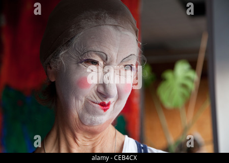 Seniorin im Whiteface Clown Make-up zieht eine Reihe von lustigen Gesichtern. Bild 1 von 8 Stockfoto