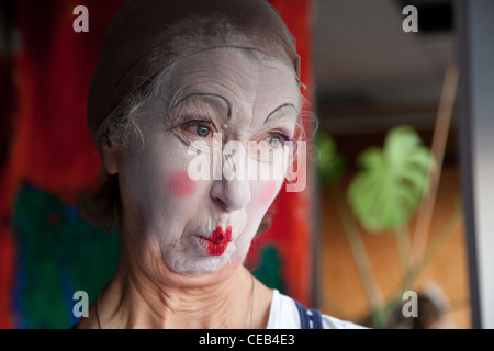 Seniorin im Whiteface Clown Make-up zieht eine Reihe von lustigen Gesichtern. Bild 2 von 8 Stockfoto