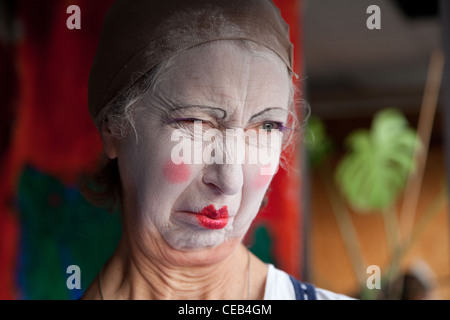 Seniorin im Whiteface Clown Make-up zieht eine Reihe von lustigen Gesichtern. Bild 4 von 8 Stockfoto