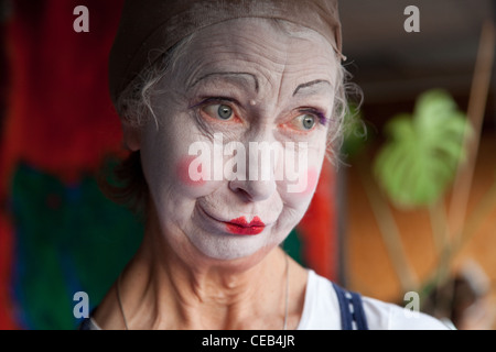 Seniorin im Whiteface Clown Make-up zieht eine Reihe von lustigen Gesichtern. Bild 6 von 8 Stockfoto