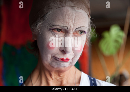 Seniorin im Whiteface Clown Make-up zieht eine Reihe von lustigen Gesichtern. Bild 7 von 8 Stockfoto