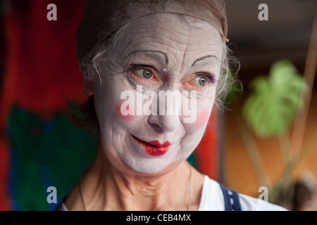 Seniorin im Whiteface Clown Make-up zieht eine Reihe von lustigen Gesichtern. Bild 8 von 8 Stockfoto