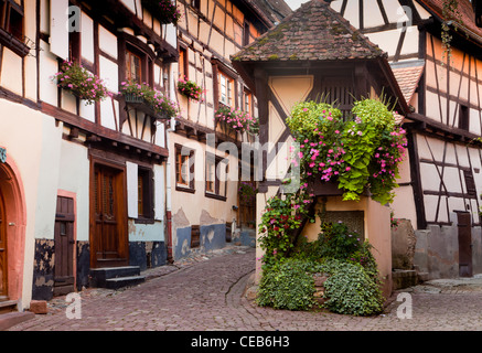 Malerische Straße mit mittelalterlichen Fachwerkhäusern in Eguisheim Dorf entlang der berühmten Weinstraße im Elsass/Frankreich Stockfoto