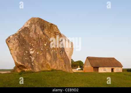 Stehenden Stein und eine Scheune am Abend, Avebury, Wiltshire Stockfoto