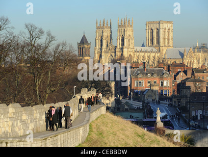 Menschen zu Fuß entlang York Stadtmauer mit York Minster im Hintergrund in der Herbstsonne Stockfoto