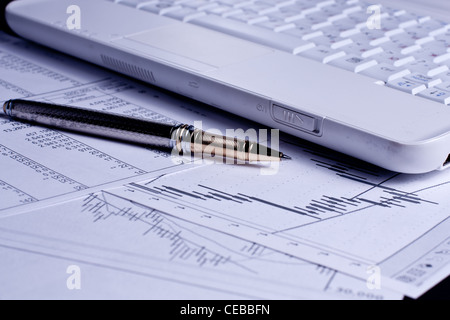 Verschiedenen Finanz-Charts mit Laptop und Stift auf den Tisch Stockfoto