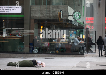 Obdachloser liegen auf dem Bürgersteig mit seinem Haustier in der Innenstadt von Toronto Stockfoto