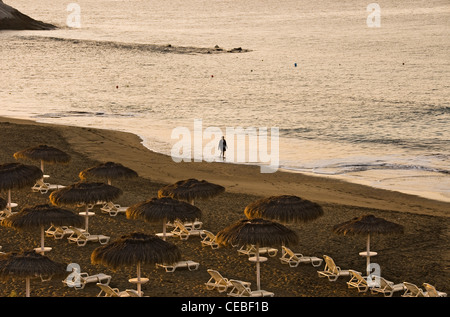 Mann allein zu Fuß am Strand, am frühen Morgen. Playa del Duque. Costa Adeje, Teneriffa, Kanarische Inseln, Spanien, Europa. Stockfoto