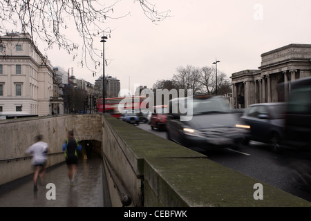 Passanten in einem u-Bahn-Eingang und Datenverkehr rund um den Kreisverkehr Hyde Park Corner, London Stockfoto