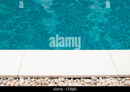 Nähe Schwimmbad, abstrakten Detail mit blauem Wasser & Kieselsteine. Stockfoto