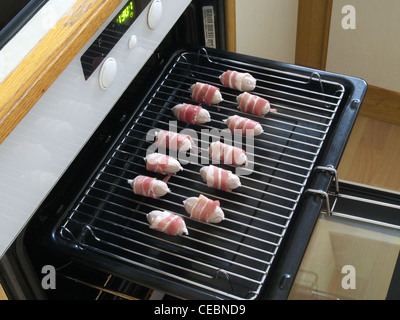 Ungekocht Schweine In decken (eingewickelt in Speck Würstchen) auf einem Grill Pan Stockfoto