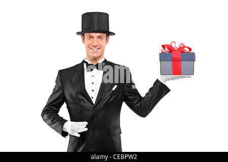 Junge Zauberer hält ein Zauberstab und ein Geschenk auf weißen Hintergrund isoliert Stockfoto