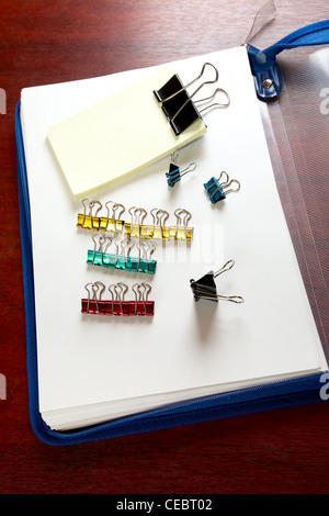 Ordner-Blätter und Büroklammern auf einem Schreibtisch Stockfoto