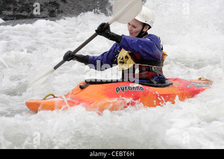 Mädchen weibliche Kanute Teilnahme an inter Hochschulwettbewerb auf Fluß Exe Exeter 02.04.12 schießen über ein Wehr Stockfoto
