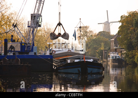 Schiff im Hafen immer auf frühen Herbstmorgen geladen. Mühle im Hintergrund Stockfoto