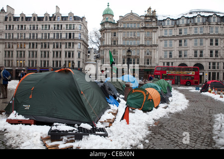 Eine Reihe von Zelten im Schnee in St. Pauls Besetzung Camp. Ein London-Bus fährt vorbei. Stockfoto