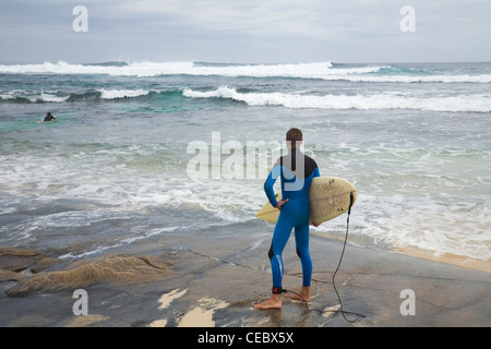 Eine Surfer blickt auf die brechenden Wellen Surfer Zeitpunkt.  Margaret River, Western Australia, Australien Stockfoto