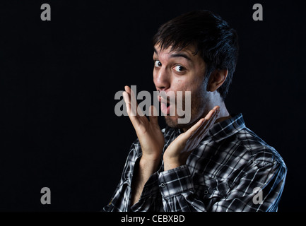 Mann mit dem Ausdruck ihrer Überraschung auf schwarz Stockfoto