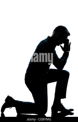 ein kaukasischer Mann kniend in voller Länge Silhouette im Studio isoliert weißen Hintergrund Stockfoto