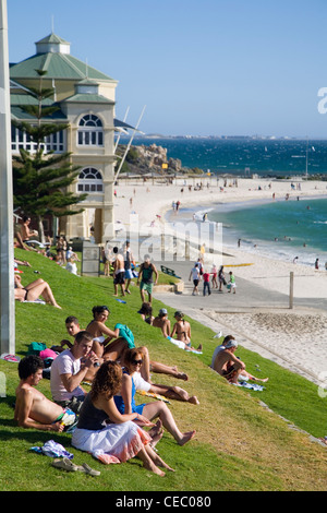 Sonnenanbeter auf den grasbewachsenen Hängen am Cottesloe Beach.  Perth, Western Australia, Australien Stockfoto