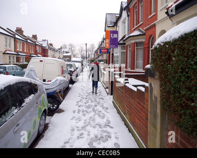 Menschen, die versuchen, auf den rutschigen fortzubewegen, Schnee bedeckt Straßen von Mitcham in Südlondon. Stockfoto