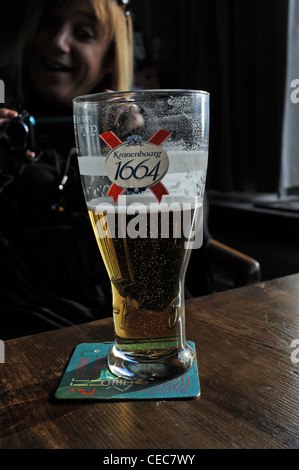 Pint Glas Kronenbourg 1664 Bier Lager in einem britischen Pub UK Glas halb voll oder leer Stockfoto