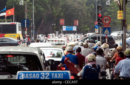 Kein Stau aber normalen Verkehr an einer Ampel in Hanoi - Busse, Autos, Taxis und viele, viele Motorräder Stockfoto