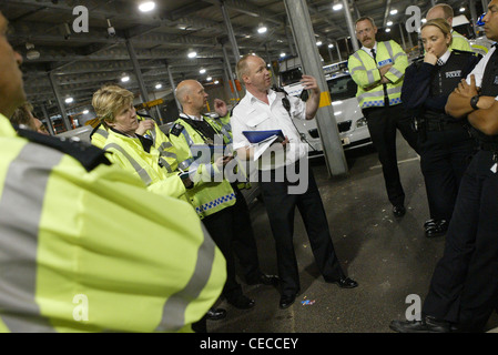 Verkehr Polizisten diskutieren Taktik in einer Besprechung in einem Lagerhaus in London, UK Stockfoto