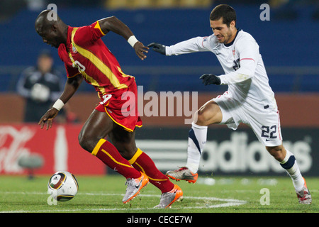 Stephen Appiah von Ghana (L) funktioniert die Kugel gegen Benny Feilhaber von der United States (R) während des 2010 FIFA World Cup Spiels. Stockfoto