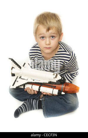 Kind blonden Jungen spielen mit Lego Space Shuttle Modell Spielzeug Ausschneiden Stockfoto