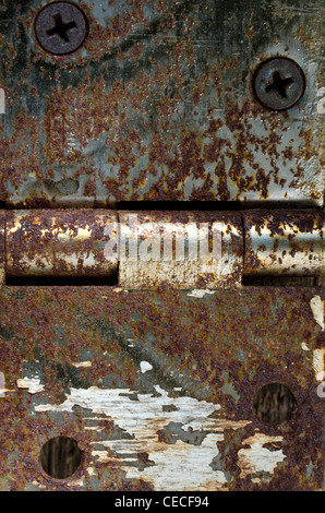 Ein Textur-Scharnier von Metall, mit Schrauben und zerkratzte hölzernen Hintergrund mit Farbe Flecken. Stockfoto