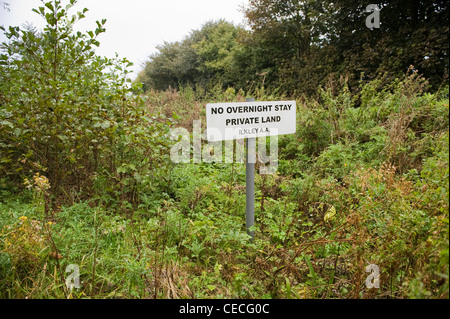 Klares Zeichen & Wegweiser auf privaten Grundstücken (Grün & bewachsen), Parken verbot Informationen ('keine Übernachtung'), Ilkley, West Yorkshire, England, UK. Stockfoto