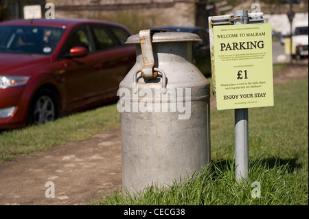 Alte Vintage Style Milchkanne (verwendet, um Geld zu sammeln) von Willkommen & Parken zahlung Vorzeichen (1 £ Parken kostenlos) - Malham, Yorkshire Dales, England, UK. Stockfoto