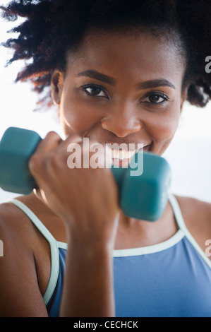 Schwarze Frau, die das Training mit Hanteln Stockfoto