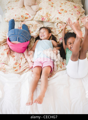 Mädchen spielen auf Bett zusammen Stockfoto