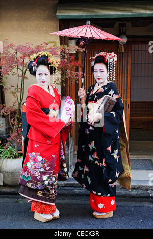 Japanische Frau, gekleidet in traditioneller Kleidung hält Regenschirm Stockfoto
