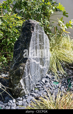 Probe grauen Stein als ein Brennpunkt-Feature in einem kleinen Garten Stockfoto