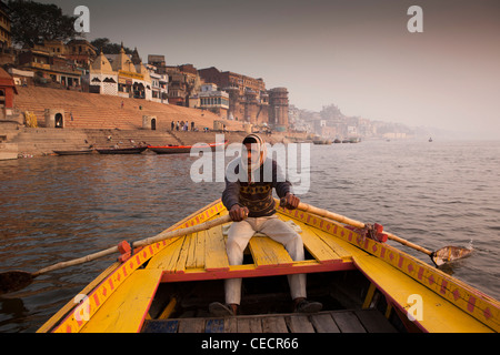 Indien, Uttar Pradesh, Varanasi, Mann Ruderboot die Touristen auf Dawn Tour am Fluss Ganges Stockfoto